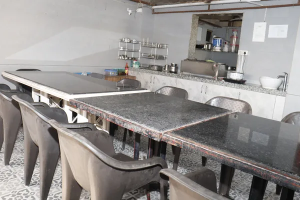 The dining hall, with granite-topped tables and the kitchen serving window behind.