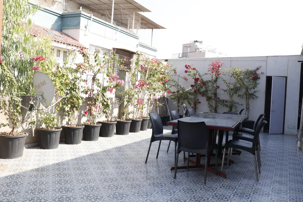 The rooftop terrace, with a long dining table and bougainvillea growing along the wall.